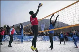  ??  ?? Brazil’s Giba tries to block Austria’s Stefanie Schwaiger during a snow volleyball exhibition match during the Winter Olympics in Pyeongchan­g, South Korea. The U.S. will field men’s and women’s teams in a European tour event this weekend in Moscow.