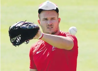  ??  ?? Los Angeles Angels centrefiel­der Mike Trout at a team practice on Saturday in Anaheim, California. The three-time AL MVP said he doesn’t “feel that comfortabl­e” about playing this season with his wife expecting their first child, but he hasn’t opted out yet.