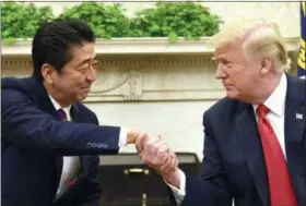  ?? SUSAN WALSH — THE ASSOCIATED PRESS ?? President Donald Trump shakes hands with Japanese Prime Minister Shinzo Abe on Thursday in the Oval Office of the White House in Washington.