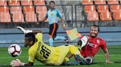  ??  ?? Futile bid: PJ City’s Safee Sali (right) fails to score past Felda United’s goalkeeper Norazlan Razali during their Super League match on Saturday. — Bernama