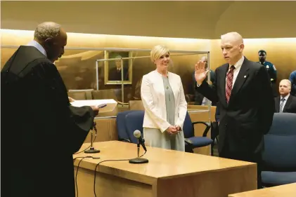  ?? SEAN FOWLER PHOTOS/SPECIAL TO THE COURANT ?? Retired Supreme Court Justice Lubbie Harper Jr. swears in Patrick Griffin as the new chief state’s attorney on Friday morning during a ceremony at the New Haven County Courthouse.