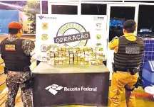  ??  ?? Los agentes de la Fuerza Nacional custodian los 160 paquetes de marihuana prensada incautados del automóvil.