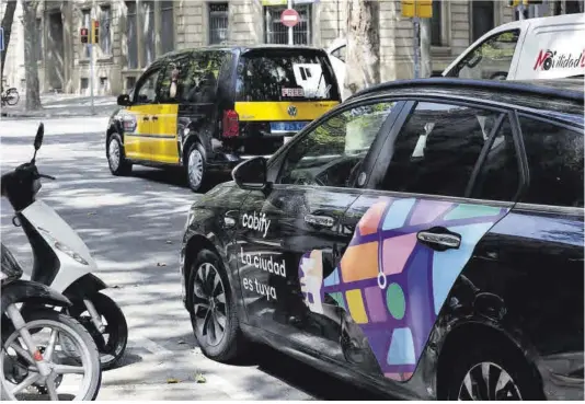  ?? Ferran Nadeu ?? Un coche de Cabify y un taxi, en la ronda de Sant Pere de Barcelona.