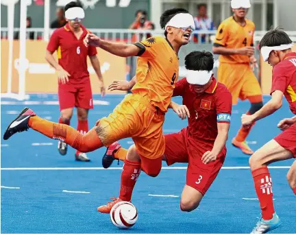  ?? — GLENN GUAN/ The Star ?? C-r-a-s-h: Amirul Arif Mahadhir colliding with Vietnam’s La Tan Hung during the five-a-side football match at the National Hockey Stadium in Bukit Jalil yesterday.