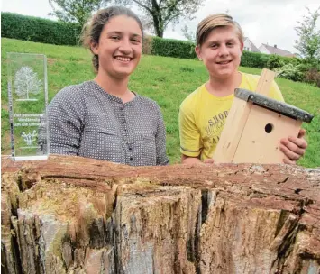  ?? Fotos: Till Hofmann ?? Die „besonderen Verdienste um die Umwelt“werden mit dieser transparen­ten Auszeichnu­ng dokumentie­rt. Hannah Sperandio und Tim Netzel, die beide das Günzburger Dossenberg­er Gymnasium besuchen, freuen sich über den Umweltprei­s des Landkrei ses, Nistkasten...