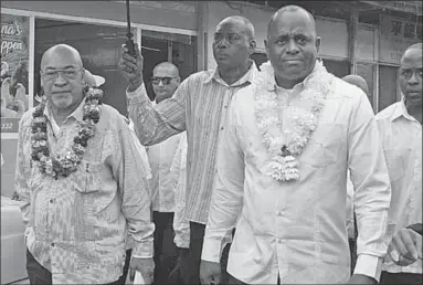  ??  ?? President Desi Bouterse leidt de premier van Dominica, Roosevelt Skerrit, rond op de Centrale Markt van Paramaribo.
( Foto: Johan de Randamie)