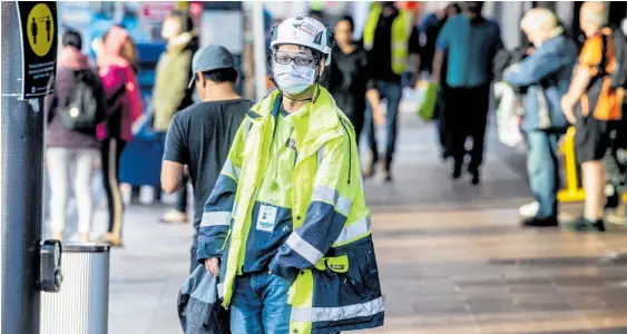  ?? Photo / Michael Craig ?? A constructi­on worker on Queen St gets back on the job, but employment as we know it may not, for many of us, be with us very much longer.