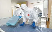  ?? Yonhap ?? Staffers at a hospital in Daegu clean a ward, Friday, after COVID-19 patients who had been hospitaliz­ed there were discharged from the hospital. The city that was once considered the local epicenter of the virus outbreak reported no new cases for the first time in 52 days.