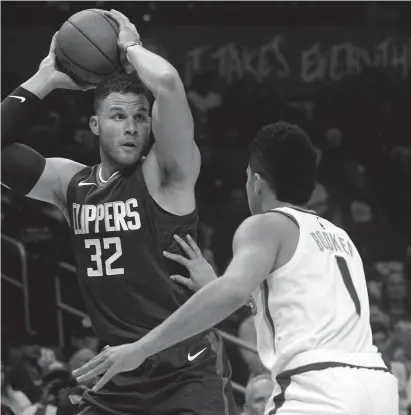  ?? GARY A. VASQUEZ/USA TODAY SPORTS ?? Clippers forward Blake Griffin (32) controls the ball against the defense of Suns guard Devin Booker (1) during the first half at Staples Center on Saturday night in Los Angeles.