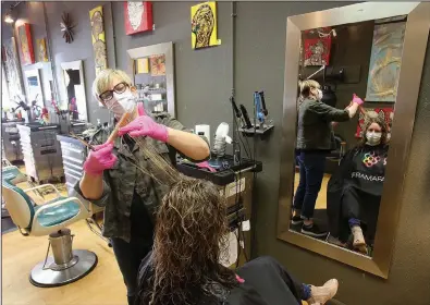  ?? (Arkansas Democrat-Gazette/Thomas Metthe) ?? Hairstylis­t Whitney Festervand cuts Michelle Foster’s hair Wednesday at Chop Salon in North Little Rock. More photos at arkansason­line.com/57hair/.