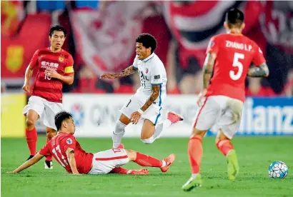  ?? AFP ?? Weverson Leandro (centre) of Japan’s Kashima Antlers fights for the ball with Liu Jian of China’s Guangzhou Evergrande during their AFC Champions League round 16 match in Guangzhou. —