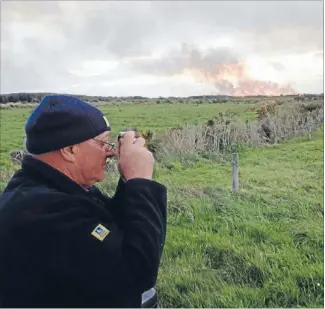  ?? Photos: ALEX FENSOME/FAIRFAX NZ ?? Where there’s smoke: Landowner Warren Owen takes a picture of the fire on Awarua conservati­on land yesterday.