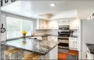  ??  ?? The updated Chef’s kitchen offers granite slab counters, a peninsula island/breakfast bar, tile backsplash and a classic Shaws farmhouse sink with a bowed front apron.