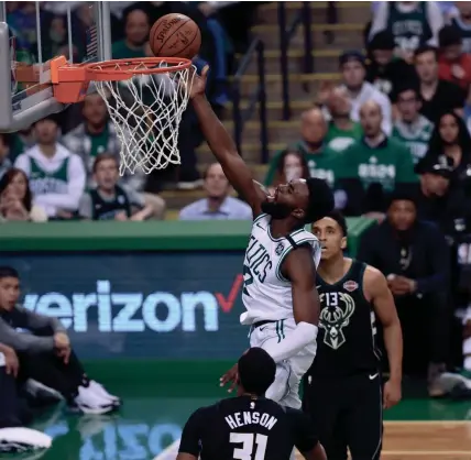  ?? BOB DECHIARA / USA TODAY SPORTS ?? Celtics guard Jaylen Brown splits John Henson and Malcolm Brogdon for a layup.