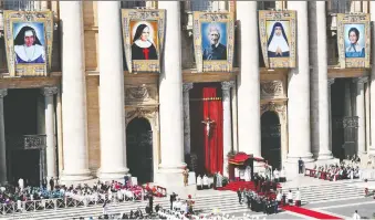  ?? ALBERTO PIZZOLI/AFP VIA GETTY IMAGES ?? Tapestries of new saints, from left, Dulce Lopes Pontes, Giuseppina Vannini, John Henry Newman, Mariam Thresia Chiramel Mankidiyan and Marguerite Bays are displayed during their canonizati­on mass, on Oct. 13, in Saint Peter’s square at the Vatican.