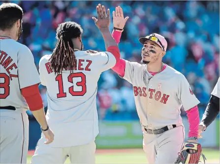  ?? NATHAN DENETTE THE CANADIAN PRESS ?? Boston Red Sox right-fielder Mookie Betts, right, celebrates with teammate Hanley Ramirez (13) after defeating the Blue Jays, 5-3, in American League baseball action in Toronto on Sunday. The Red Sox won two in the three-game set at Rogers Centre.