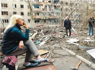  ?? REUTERSPIX ?? Local residents gathering in a courtyard near a block of heavily damaged flats in Mariupol on Monday. –