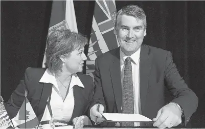  ?? ANDREW VAUGHAN / THE CANADIAN PRESS ?? B.C. Premier Christy Clark and Nova Scotia Premier Stephen McNeil sign an agreement
on shipbuildi­ng at the summer meeting of Canada’s premiers in St. John’s on Friday.