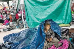  ?? AP PHOTO BY HANS-MAXIMO MUSIELIK ?? A girl who traveled with the caravan of Central American migrants awakens where the group set up camp outside the El Chaparral port of entry building at the U.S.-Mexico border in Tijuana, Mexico. The migrants are waiting for access to request asylum in...