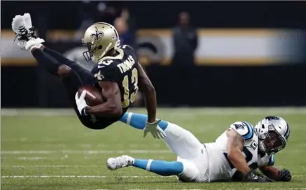  ?? GERALD HERBERT, THE ASSOCIATED PRESS ?? Saints wide receiver Michael Thomas is upended by Carolina Panthers free safety Kurt Coleman in the first half of their National Football League game Sunday in New Orleans. The Saints won the contest, 31-21, to break a tie atop the NFC South. For...