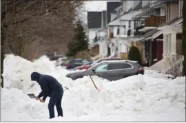  ?? JEFFREY T. BARNES — THE ASSOCIATED PRESS ?? A person removes snow from the front of a driveway in Buffalo, N.Y., Thursday, a few days after a winter storm rolled through western New York.