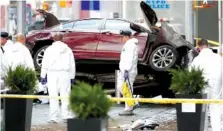  ?? THE ASSOCIATED PRESS ?? Police officers look over evidence at the scene of a fatal car crash, where a man steered his car onto a sidewalk and mowed down pedestrian­s in Times Square in New York on Thursday.