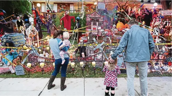  ??  ?? A family comes to look at the Halloween display at Chris Donaubauer’s front yard on the 600 block of Nancy Drive, in St Charles, Missouri. — Photos: TNS