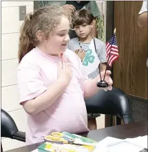  ?? Katie West • Times-Herald ?? Quinn Boeckmann, left, holds the 4-H and American flags during the opening of St. Francis County Amigos monthly 4-H meeting. The group met to prepare displays for the 4-H booths at the St. Francis County Fair. The group also welcomed new members such as Paxton Billingsle­y, at right.