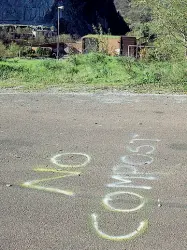  ??  ?? Una scritta lasciata sull’asfalto vicino all’impianto di compostagg­io (nella foto accanto), chiuso da tre mesi ma con 5mila tonnellate di rifiuti dentro. Che continuano a spargere cattivi nella valle