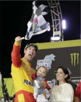  ?? TERRY RENNA — THE ASSOCIATED PRESS ?? Joey Logano waves a checkered flag as he stands with his wife Brittany Baca and son Hudson after winning NASCAR Cup Series Championsh­ip auto race at the HomesteadM­iami Speedway, Sunday in Homestead, Fla.