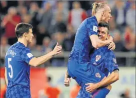  ?? AP ?? Croatia's Domagoj Vida (center) celebrates with teammates after their World Cup qualificat­ion.