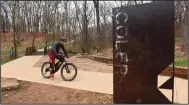  ?? (NWA Democrat-Gazette/Flip Putthoff) ?? Damon Bourne of Madison, Wis., rides a hard-surface trail on Tuesday March 23 2021 after pedaling the soft-surface mountain bike trails at Coler Preserve in Bentonvill­e. Bourne has made three trips in two years from Wisconsin to Northwest Arkansas to mountain bike in the area. "I've spent today getting beat up," he said after riding some of the park's more technical routes. Go to nwaonline.com/210324Dail­y/ to see more photos.