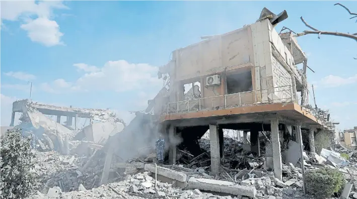  ?? AP ?? Escombros. Un bombero apaga las últimas llamas en el destruido centro sirio de investigac­ión científica en Barzeh, cerca de Damasco, uno de los blancos atacados el viernes.