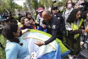  ?? RICHARD VOGEL — THE ASSOCIATED PRESS ?? Protesters at USC fight with university officers who are trying to remove tents at the campus' Alumni Park during a proPalesti­nian rally Wednesday. The school's main graduation ceremony was supposed to be at the park.