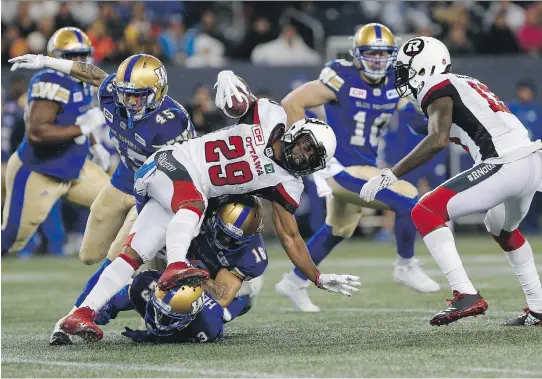  ?? OHN WOODS/THE CANADIAN PRESS ?? Redblacks’ William Powell gets tackled by Blue Bombers’ Jovan Santos-Knox (45), TJ Heath (23) and Taylor Loffler (16) in Winnipeg on Friday night.