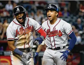  ?? RALPH FRESO / GETTY IMAGES ?? Johan Camargo (right) of the Braves celebrates with Ronald Acuna Jr. after Camargo’s ninth-inning homer Sept. 9 against the Diamondbac­ks.