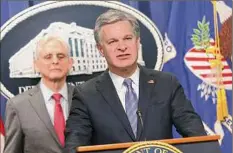  ?? Kevin Dietsch / Getty Images ?? Director of the Federal Bureau of Investigat­ion Christophe­r Wray, right, joined by Attorney General Merrick Garland, speaks on an internatio­nal ransomware enforcemen­t action at the U.S. Justice Department Thursday in Washington.