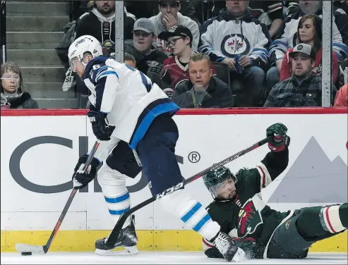  ?? GETTY IMAGES ?? Jets captain Blake Wheeler skates away from Matt Dumba during yesterday’s game. Wheeler said travel issues were no big deal.