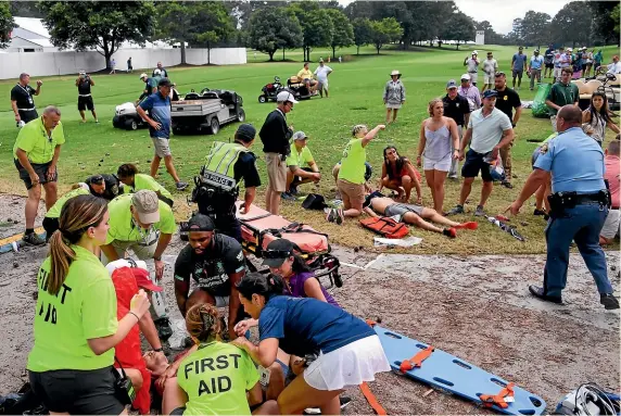  ?? AP ?? Spectators are tended to after the lightning strike during the Tour Championsh­ip at East Lake Golf Club in Atlanta.