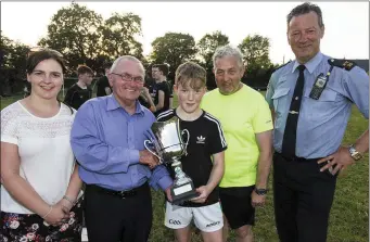  ?? Photo by John Reidy. ?? The late Georgie O’Callaghan’s twin brother, Jamesie, presenting the Georgie O’Callaghan Memorial Cup to Agri Spec Under-15 team captain, James Kenny. With: Helena Falvey, KDYS; Jim O’Connor, referee; and event founder, Sgt John O’Mahony.