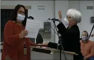  ?? IMAGE FROM SCREENSHOT ?? Betsy Ruch, right, takes the oath of office Monday after being sworn in as the newest member of the Phoenixvil­le School Board.