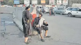  ?? REUTERS ?? Two Taliban soldiers talking to each other on a road in Kabul.