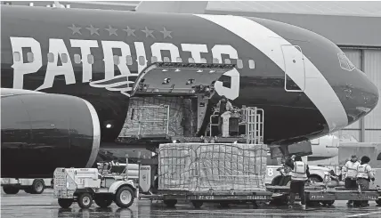  ??  ?? Logan Airport workers offload 1.2 million N95 masks from the New England Patriots plane, returning from Shenzhen, China, to help medical personnel treat patients with the coronaviru­s in Boston, Massachuse­tts.