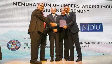  ??  ?? Sheikh Fahmy (right) shaking hands with Syed Hassan as Nazri (centre) looks on during the MoU signing ceremony at the Malaysia Tourism Centre.