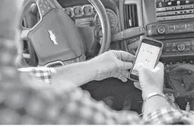  ?? James Durbin / Midland Reporter-Telegram ?? Tim Greer of Lenorah Operators shows off technology on his smartphone that allows him to track his fleet vehicles in real time. But some aspects of the oil and gas business still rely heavily on old-fashioned paper and pencil bookkeepin­g.