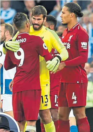  ??  ?? Klopp, left, spent £142m on two of the main “bricks” in the Reds’ defensive wall, Alisson and van Dijk (above, with Fermino)