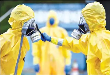  ?? AFP ?? Firefighte­rs wearing protection suites participat­e in an instructio­n as a form of contingenc­y and security against the spread of the new coronaviru­s Covid-19, in Minas Gerais, Brazil. The raging pandemic has forced lockdowns in 35 countries.