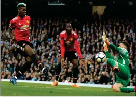  ?? ASSOCIATED PRESS ?? Manchester United’s Paul Pogba scores his side’s first goal past Manchester City goalkeeper Ederson, right, during the English Premier League soccer match between Manchester City and Manchester United at the Etihad Stadium in Manchester, England,...