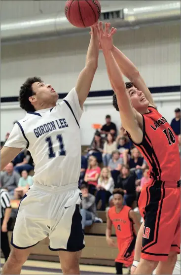  ??  ?? Gordon Lee’s Kannen Derryberry and LaFayette’s Andrew Pendergras­s battle for a rebound during the all-Walker County clash in Chickamaug­a this past Saturday. The Ramblers claimed a 55-41 win after the Lady Trojans won the opener, 50-27. (Messenger...