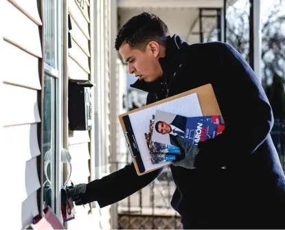  ?? TYLER LARIVIERE/SUN-TIMES FILE ?? Illinois Rep. Aaron Ortiz leaves a flyer at a home while campaignin­g for 14th Ward committeep­erson in 2019.